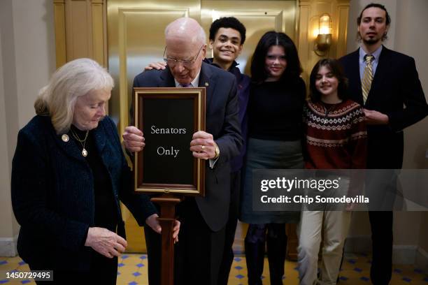 Sen. Patrick Leahy and his wife Marcelle Leahy move a sign before posing for photographs with their grandchildren Patrick Jackson, Sophia Jackson,...