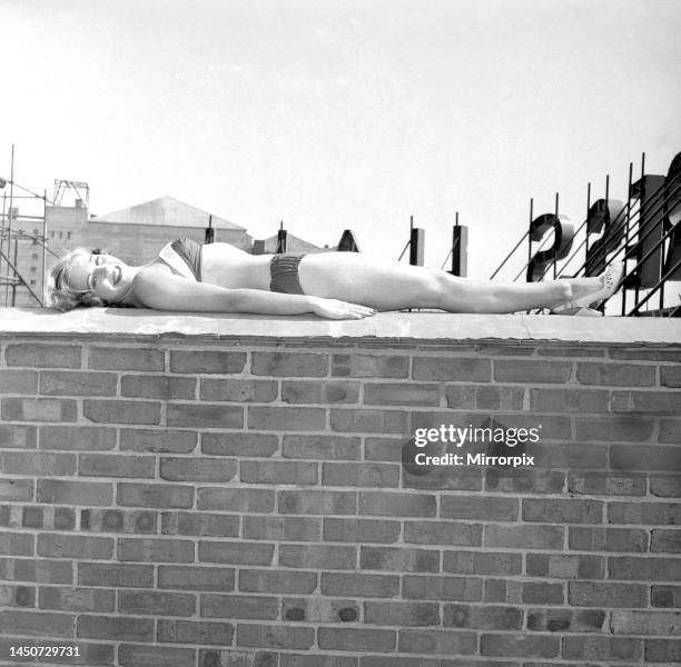 Eighteen year old Marlene Lister poses while sunbathing in a bikini on a wall of a roof terrace in Kensington, LondonShe has gained a silver medal in...