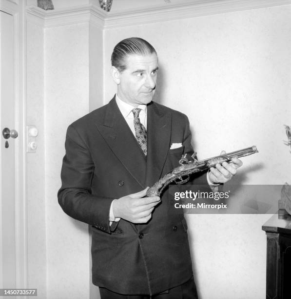 Pip Roberts a collector of antique firearms, seen here demonstrating a flintlock pistol, circa 1957.