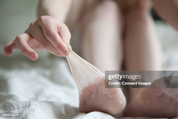 woman pulling tights away from her toes - strumpfhose stock-fotos und bilder