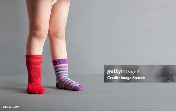 child wearing one red sock and one striped sock - mismatch fotografías e imágenes de stock