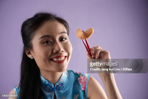 women with cheongsam holding fortune cookie using chopsticks,malaysia - chinese takeout stock pictures, royalty-free photos & images