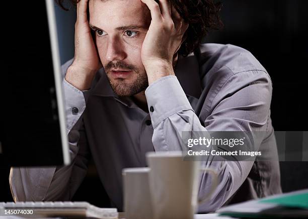 stressed young man, working late - head in hands computer stock pictures, royalty-free photos & images