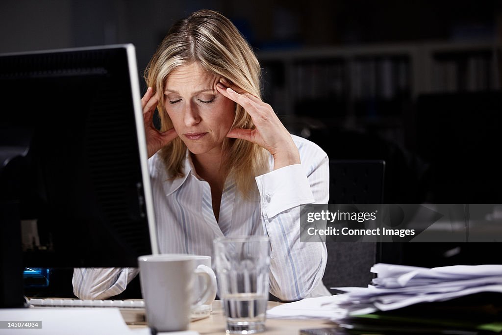 Stressed businesswoman working late