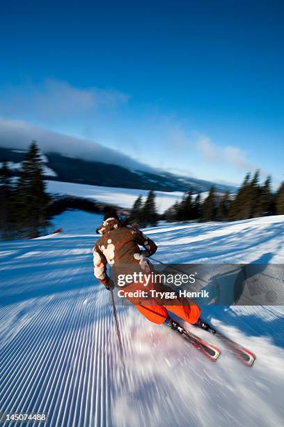 skier going down slope, rear view - alpineskiën stockfoto's en -beelden