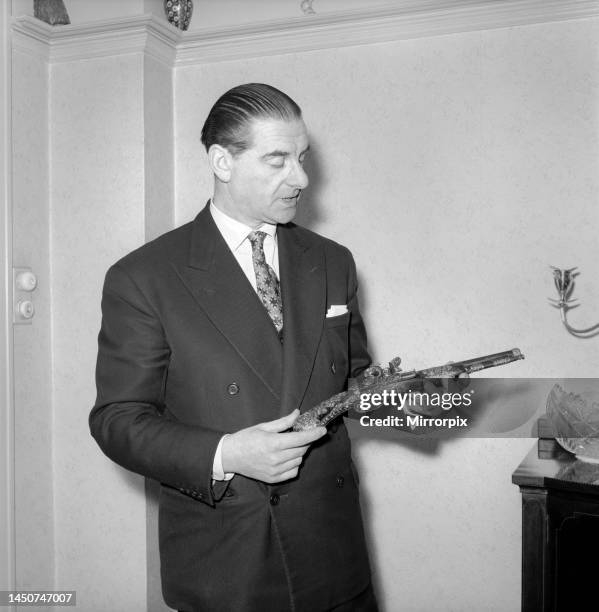 Pip Roberts a collector of antique firearms, seen here demonstrating a flintlock pistol, circa 1957.