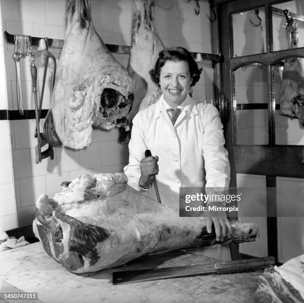 Female butcher seen here at work. 1954.