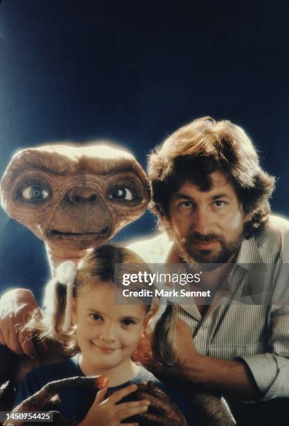 Steven Spielberg and Drew Barrymore pose with E.T. At Carlo Rimbaldi studio in April, 1982 in Los Angeles, California.