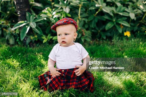 an infant turns one and enjoys a healthy cake at his birthday party. - kilt stock pictures, royalty-free photos & images