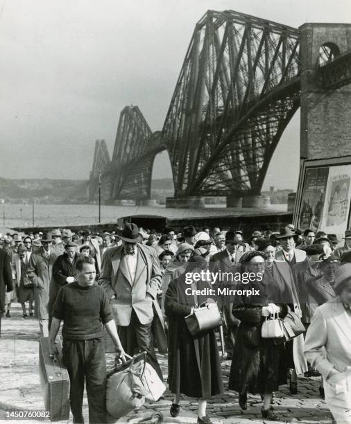 Tourists come ashore from the cruise ship Caronia at South Queensferry with Forth Rail bridge in background. April 1957.