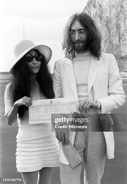 Beatles singer John Lennon and his new bride Yoko Ono holding their marriage certificate after their marriage in Gibraltar. 20 March 1969.