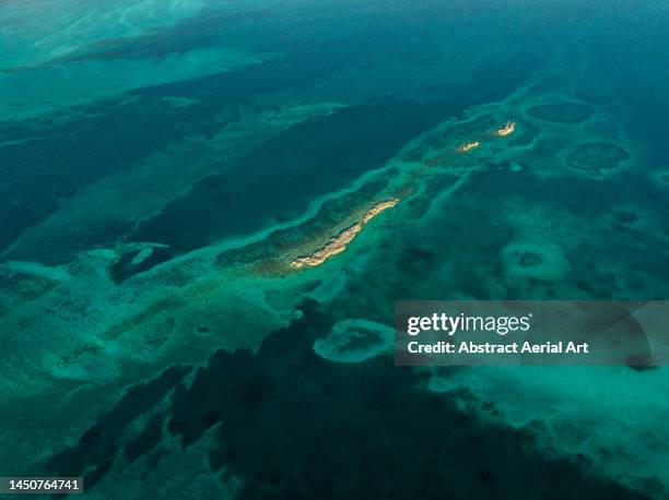 aerial shot showing a small island off the coast of nassau surrounded by coral reef, new providence, bahamas - new providence - fotografias e filmes do acervo