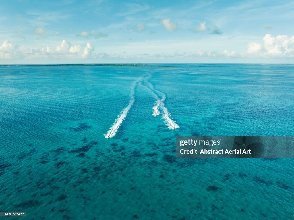 Aerial view showing three jet-skis speeding across the Ocean off the coast of Nassau, New Providence, Bahamas