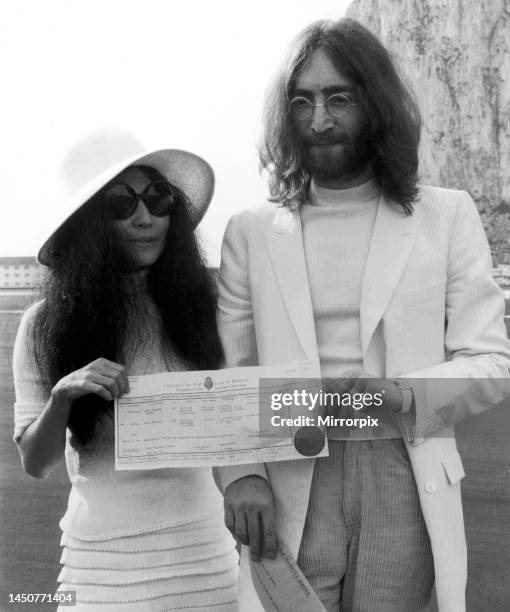 Beatles singer John Lennon and his new bride Yoko Ono holding their marriage certificate after their marriage in Gibraltar. 20 March 1969.