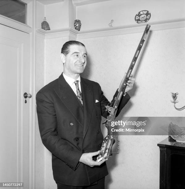 Pip Roberts a collector of antique firearms, seen here demonstrating a flintlock pistol, circa 1957.