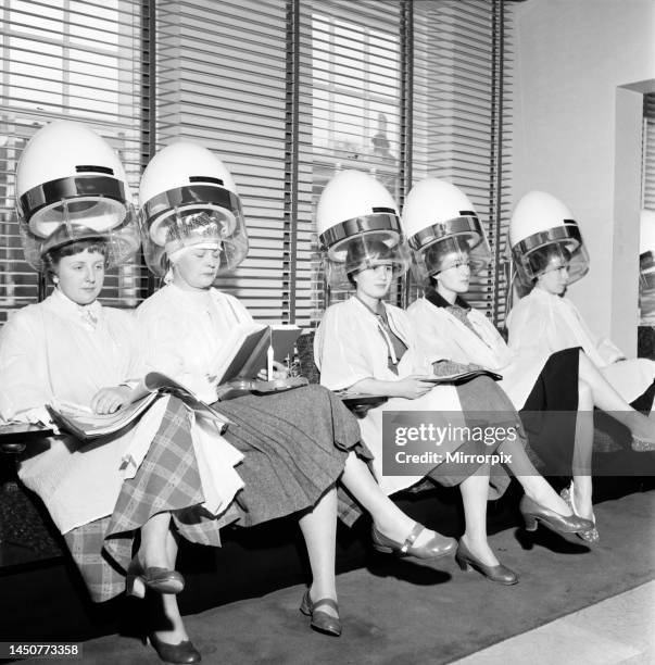 Women at the hairdressers seen here under the driers, April 1956.