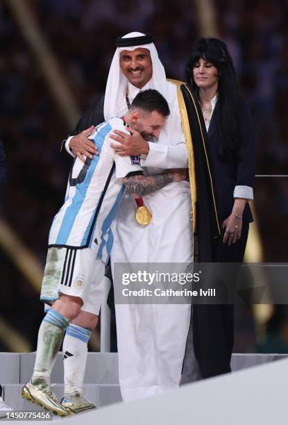 Lionel Messi of Argentina is embraced by Sheikh Tamim bin Hamad Al Thani, Emir of Qatar, during the awards ceremony after the FIFA World Cup Qatar...