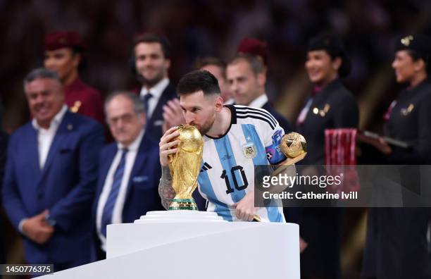 Lionel Messi of Argentina kisses the FIFA World Cup Winners' Trophy while holding the adidas Golden Boot award after the FIFA World Cup Qatar 2022...