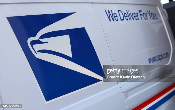 The United States Postal Service logo is seen on a new electric postal vehicle during an event announcing the Postal Service's plan on implementing...