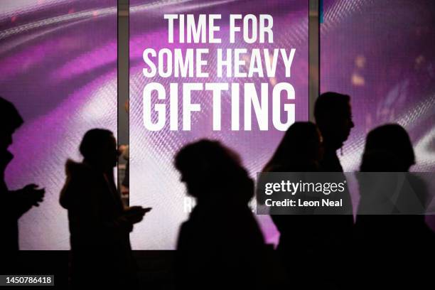 Shoppers walk past a window display on December 20, 2022 in London, England. After November's retail figures were down 0.4% on the previous year and...