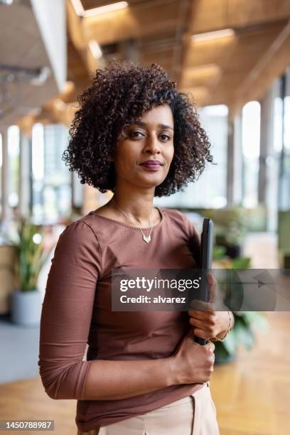 portrait of confident african businesswoman with digital tablet in office - director office stock pictures, royalty-free photos & images