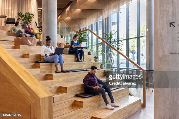 group of people working at creative office - wooden staircase stock pictures, royalty-free photos & images