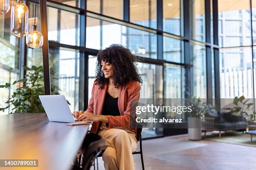 Young African woman working on laptop at office cafe Young African woman working on laptop at office cafe