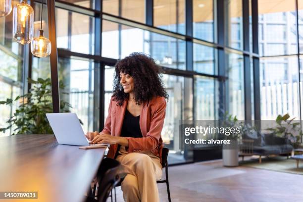 young african woman working on laptop at office cafe - átrio de hotel imagens e fotografias de stock