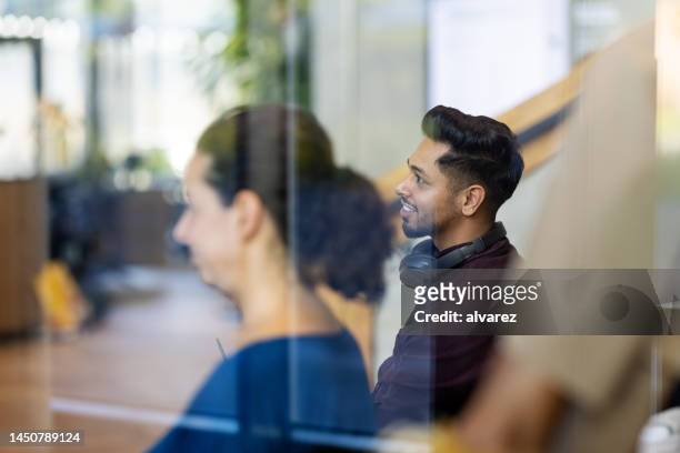 young man sitting with colleague at conference - zoom participant stock pictures, royalty-free photos & images
