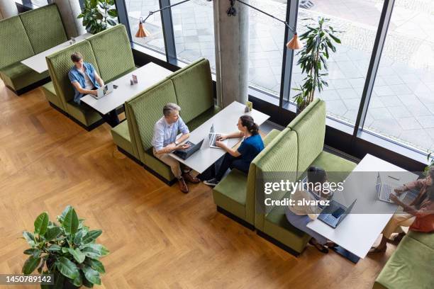 business people with laptops working at a restaurant - overhead view of meeting stock pictures, royalty-free photos & images