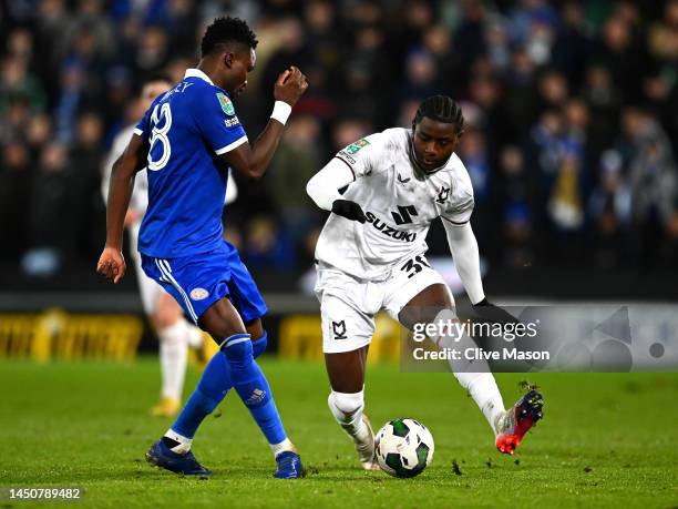 Daniel Amartey of Leicester passes under pressure from Matthew Dennis of MK Dons during the Carabao Cup Fourth Round match between Milton Keynes Dons...