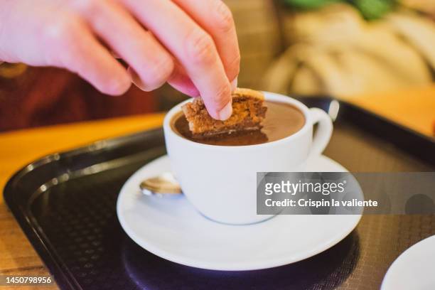 cropped hand of woman dipping cookie in hot chocolate - dip stock pictures, royalty-free photos & images