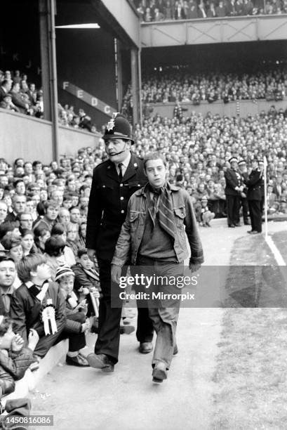 Derby County versus Manchester United. PC Wally Buswell, aged 37, escorts a young boy after he was arrested for threatening behaviour. 28th October...