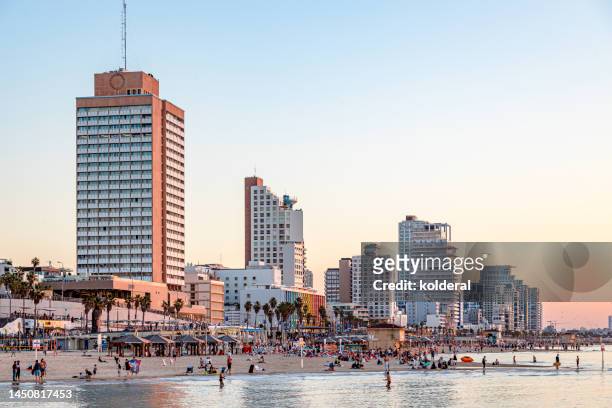 luxury waterfront hotels of tel aviv, people on mediterranean beach during sunset - israel city stock pictures, royalty-free photos & images