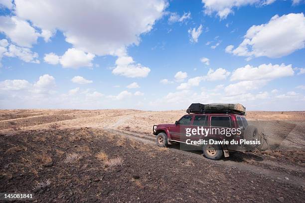 four-wheel drive on volcanic rocks in desert, loiyangalani  region, lake turkana, kenya - lago turkana foto e immagini stock