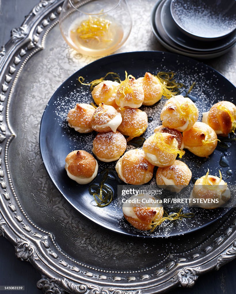 Plate of cream puffs with orange peel