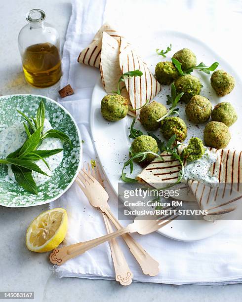 plate of spinach meatballs with yogurt - falafel stock pictures, royalty-free photos & images