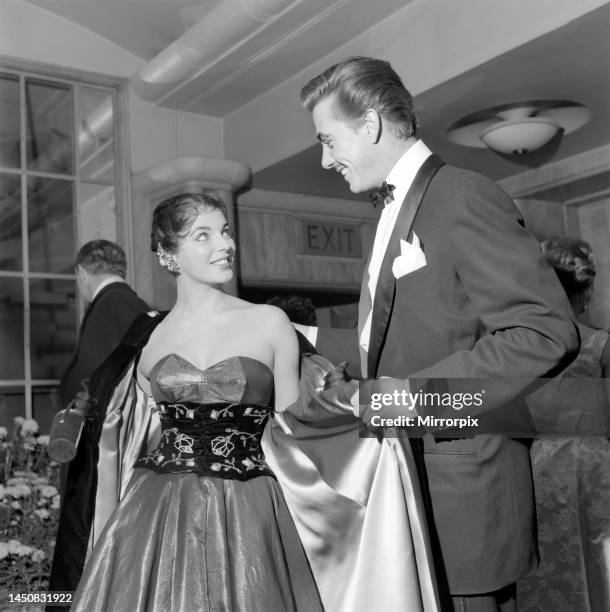 The premiere of the new cinemascope film The Robe took place this evening at the Odeon Cinema, Leicester Square. Maxwell Reed helps his wife Joan...