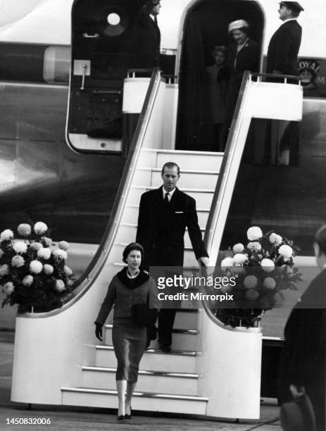 Queen Elizabeth II and Prince Philip walk down the gangway from their plane on their return from a state visit to Canada and the United States. The...
