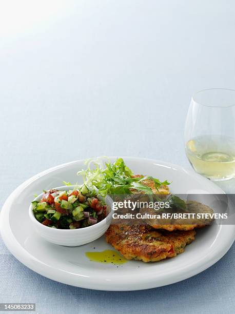 plate of fish cakes and salad - peixe à milanesa imagens e fotografias de stock