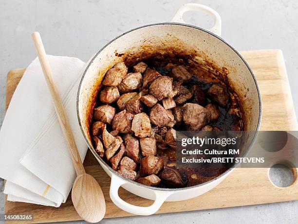 browned meat in dutch oven - rindfleischeintopf stock-fotos und bilder