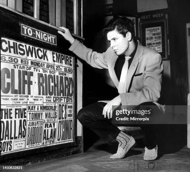 Cliff Richard looking at a concert poster with his name as top billing. 1958.