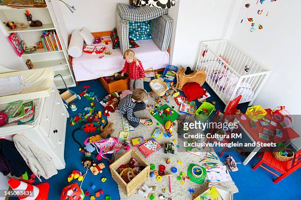 children playing in messy nursery - kinder spielzeug stock-fotos und bilder