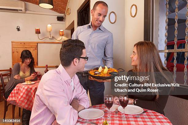 waiter serving couple in restaurant - diversity showcase arrivals stock pictures, royalty-free photos & images