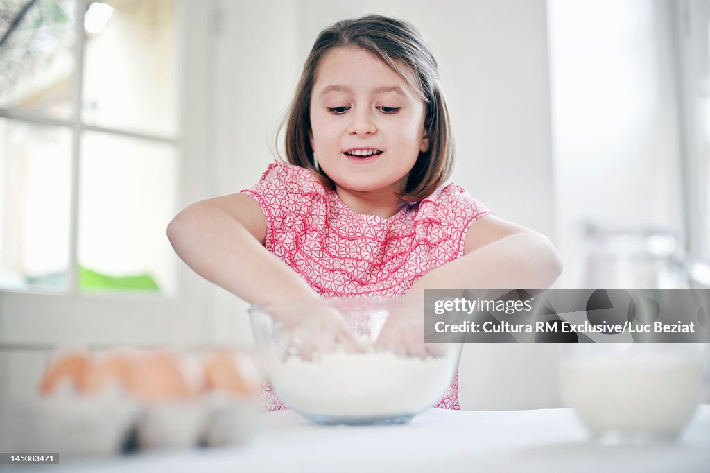Smiling girl baking in kitchen