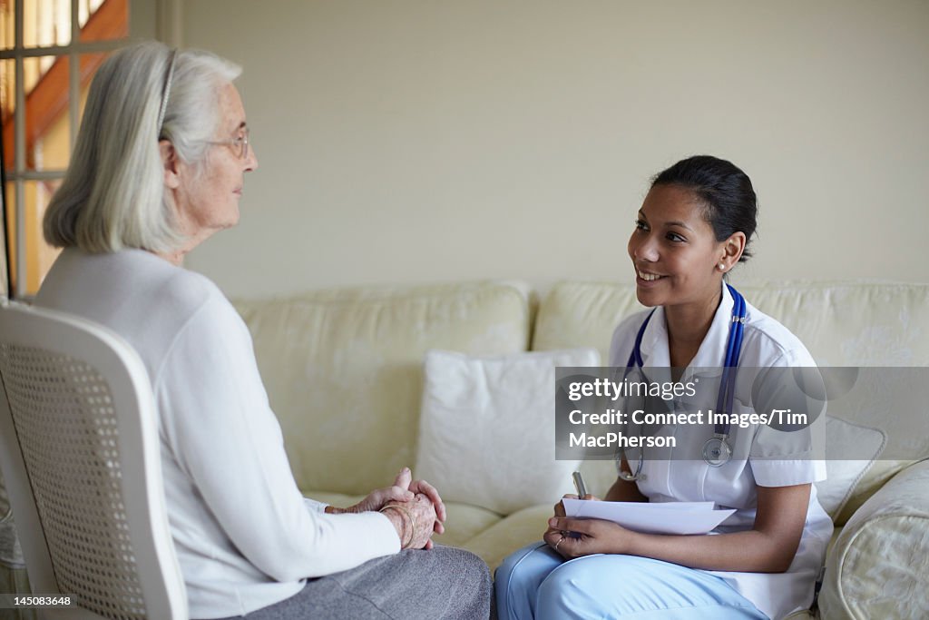 Nurse talking with older woman in home