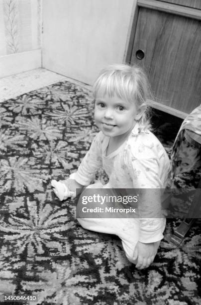 Three year old girl playing at home. November 1969.