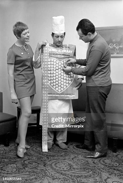 Man and woman covering a man in a Chef's uniform in plastic hearts. November 1969.