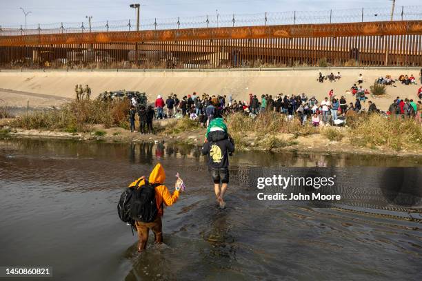 Immigrants wade across the Rio Grande at a high-traffic illegal border crossing area into El Paso, Texas on December 20, 2022 as viewed from Ciudad...