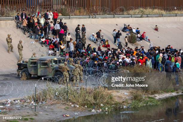 Texas National Guard troops block immigrants from entering a high-traffic border crossing area along Rio Grande in El Paso, Texas on December 20,...